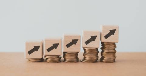 Stijgende stapeltjes munten, rente stijging symboliserend